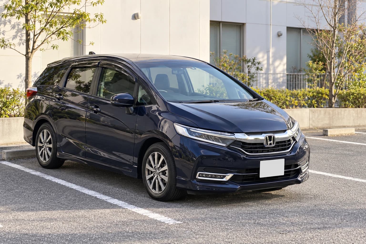 Тёмно-синий Honda Shuttle поколения 2015 года у светлого здания