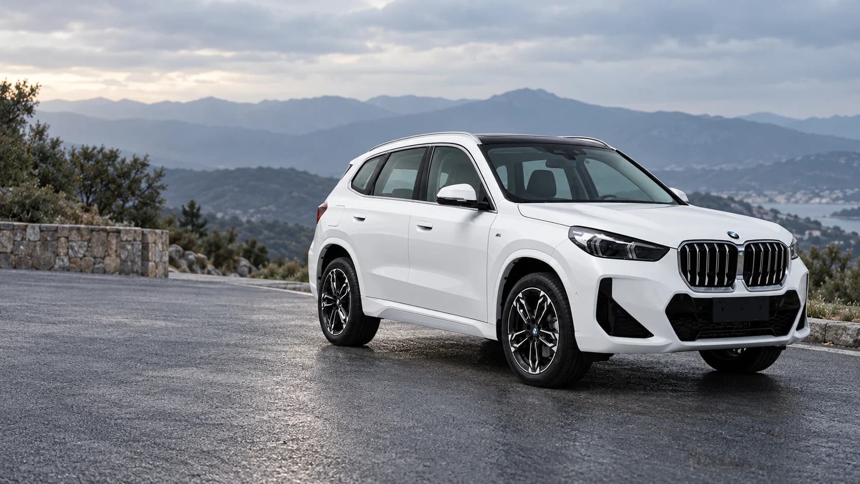 Белый BMW X1 на открытой площадке у горной дороги