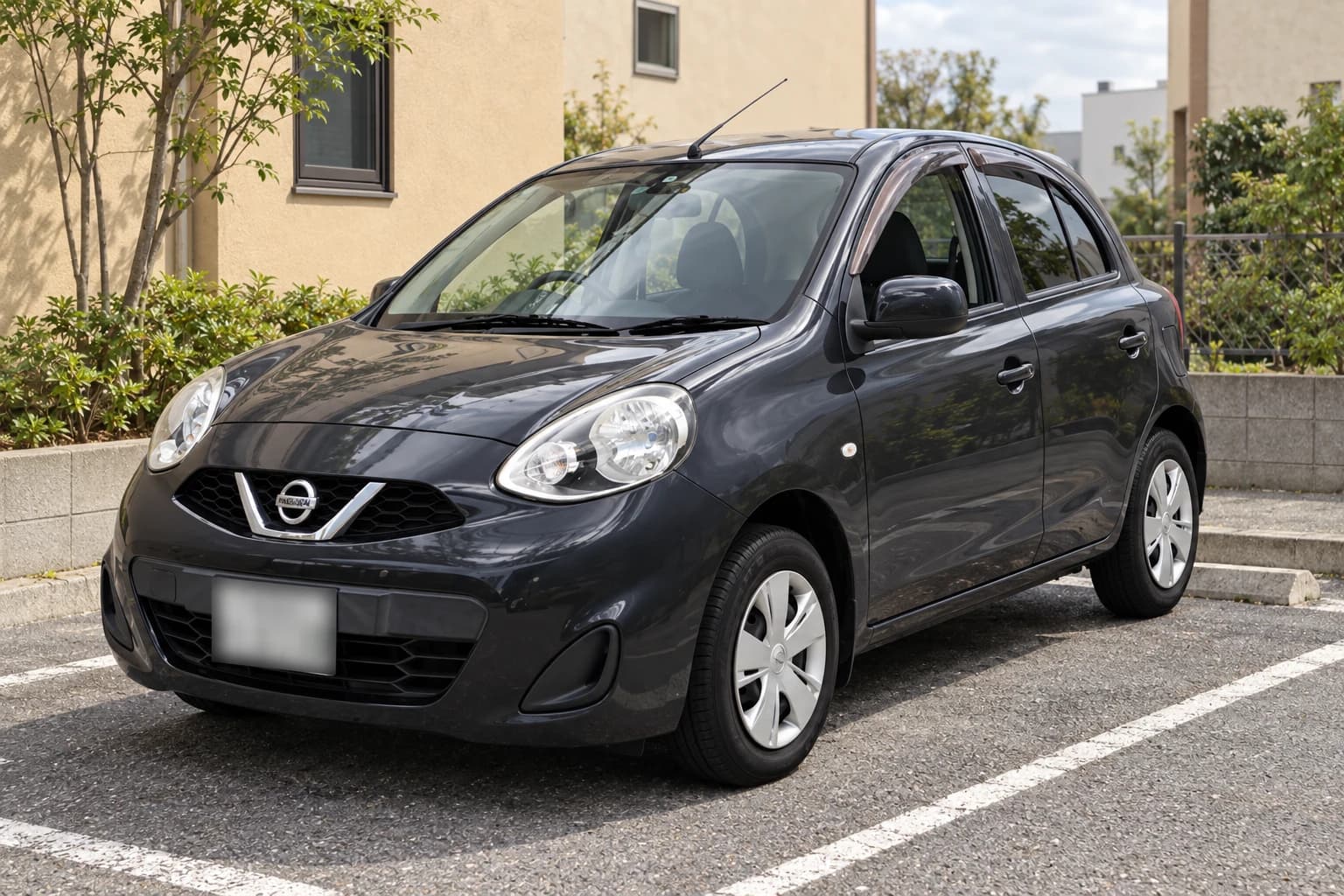 Серый Nissan March K13 после обновления передней части, вид спереди и сбоку